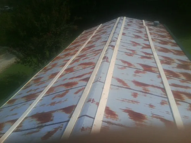 Rusted metal roof panels with new wood purlins before replacement — Storm Damage Roof Repair in Kilmarnock by Roofing Brothers