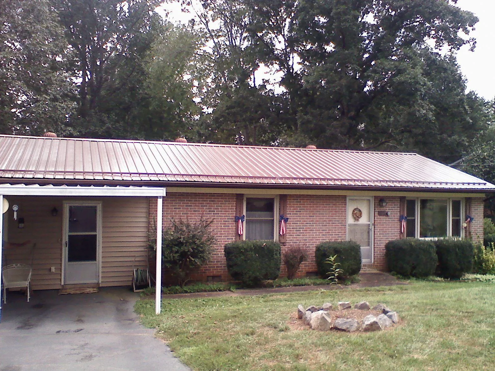 Bronze metal roof and carport on a brick ranch home — Roof Repair work by our crew in Kilmarnock